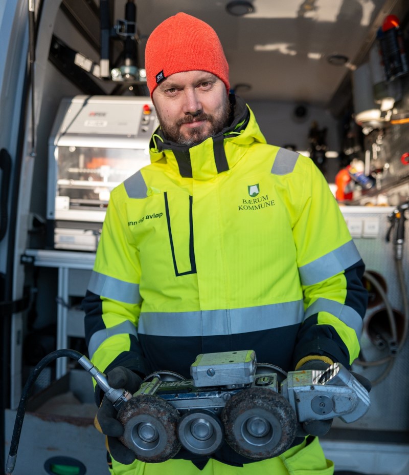 Profilbilde av ansatt som viser frem traktor med kamera for rørinspeksjon 