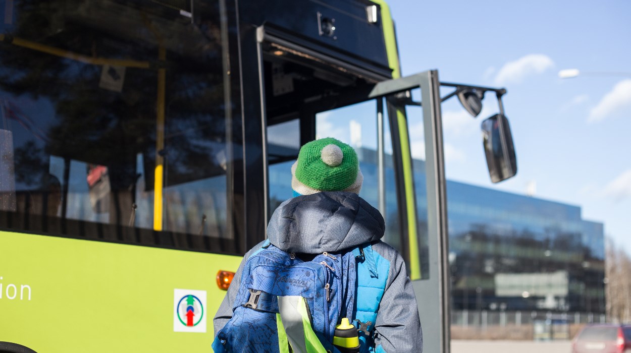 Bussholdeplass - gutt med lue som skal gå på bussen